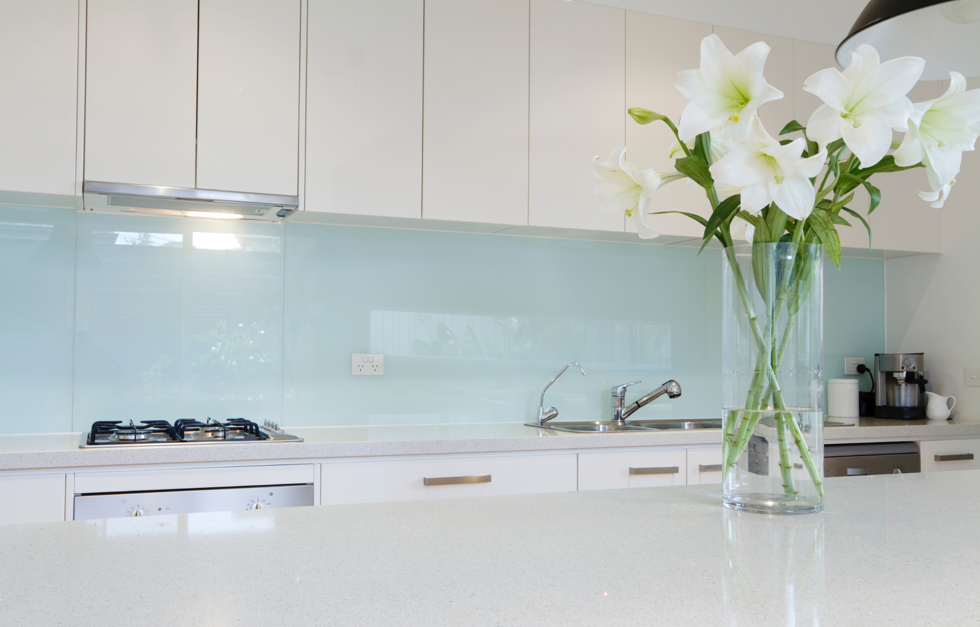 Modern kitchen with custom back-painted low-iron glass splashback.