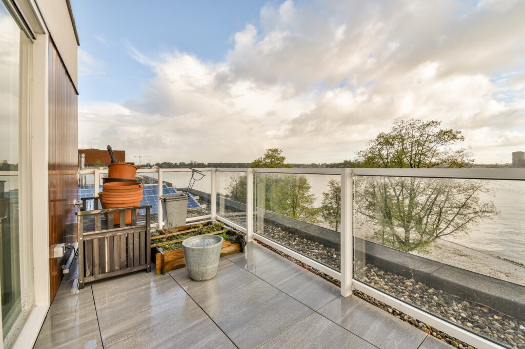 Deck glass balustrade enclosing a tiled Brisbane patio overlooking water
