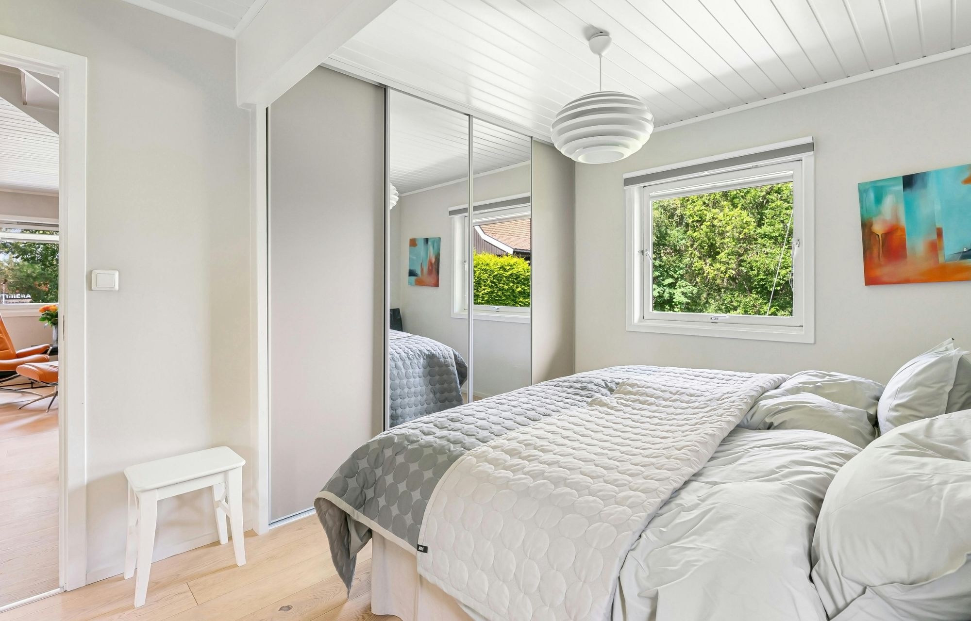 Sliding mirrored glass wardrobe doors installed in a modern Brisbane bedroom showing reflected natural light